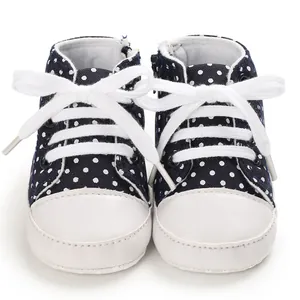 Detaillierte Nahaufnahme von dunkelblauen Baby-Canvas-Schuhen mit weißen Punkten