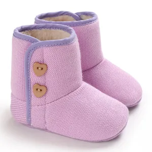 Close-up van paars gebreide babywinterlaarzen met zachte fleecevoering en hartjes