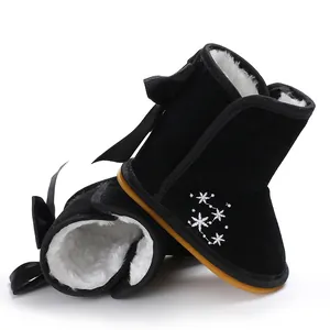 Detailansicht schwarzer Baby-Schneestiefel mit weißem Fellfutter und Schneeflocken