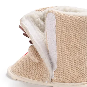 Détail de bottes de neige tricotées pour bébé avec fermeture velcro et doublure polaire