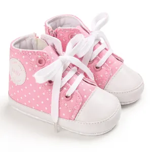 Detail von rosa gepunkteten Baby-Stoffschuhen mit weicher Sohle und Reißverschluss
