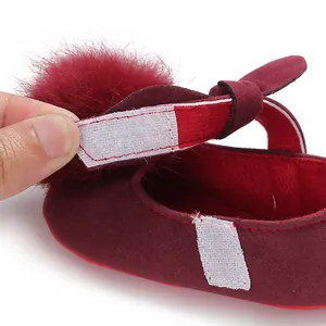Vue détaillée de la bride Velcro sur chaussure bébé rouge vin avec pompon en peluche