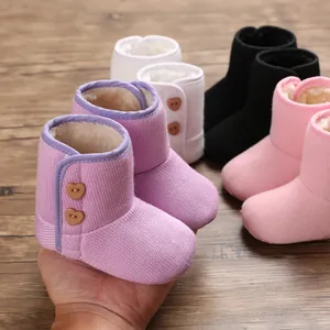 Detailweergave van baby wintersneeuwlaarzen in meerdere kleuren met hartvormige knopen.