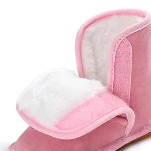 Nahaufnahme des warmen weißen Kunstfellfutters und Klettverschlusses bei rosa Babystiefeln