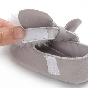 Gros plan sur la fermeture velcro réglable d'une chaussure de bébé en daim gris