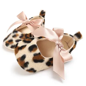 Gros plan de chaussures bébé léopard avec de grands nœuds en satin rose