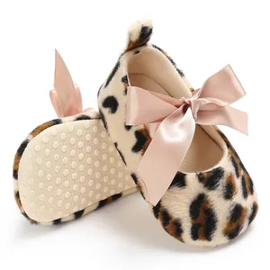 Détail de chaussures bébé imprimé léopard avec un nœud rose doux et une semelle antidérapante