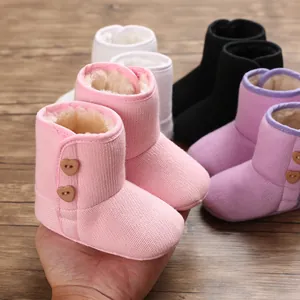 Close-up van roze gebreide babylaars met zachte fleecevoering en hartvormige knopen