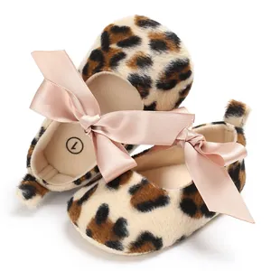 Gros plan de chaussures de marche pour bébé à motif léopard et nœuds en satin rose