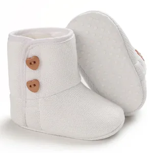 Detailweergave van witte baby-sneeuwlaarzen met hartknoppen en zachte antislipzool