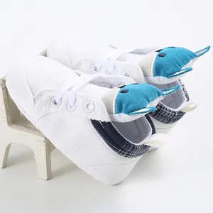 Dettaglio laterale di scarpine primi passi per neonati in tela bianca con volpe blu