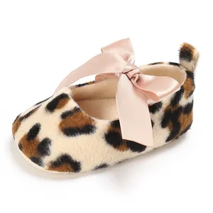 Vue détaillée d'une chaussure pour bébé léopard avec un grand nœud en satin rose