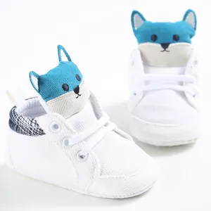 Dettaglio di scarpe primi passi bianche per neonati con design a volpe blu.
