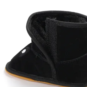 Detailed close-up of warm black fleece-lined baby boot with adjustable velcro strap