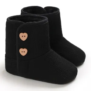 Detailweergave van zwarte gebreide babylaarzen met hartvormige knopen en fleece voering.