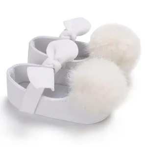 Chaussures de marche blanches pour bébé fille avec un gros pompon en fourrure et nœud