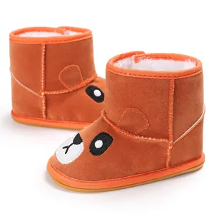 Detail view of brown winter baby boots with cute cartoon bear face and warm fleece lining