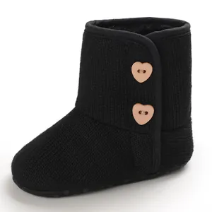 Zijaanzicht van zwarte gebreide babylaarzen met schattige hartvormige knopen voor winter