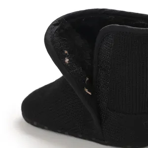 Detail van de pluche voering en klittenbandsluiting op de zwarte babylaarsjes.
