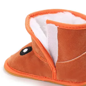 Detailed view of orange baby winter boot with white fleece lining and Velcro strap