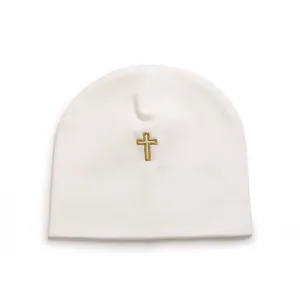 Detailed view of a soft white cotton baby beanie featuring a gold embroidered cross