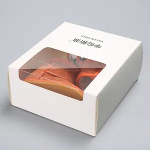 Detailed view of winter warm baby shoes inside a white windowed gift box packaging