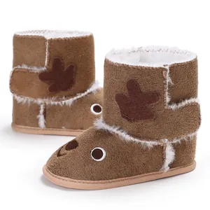 Close-up of brown baby winter boots with cute reindeer cartoon design and plush lining