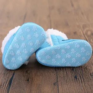 Bottom view of blue baby winter boots showing non-slip paw print sole pattern