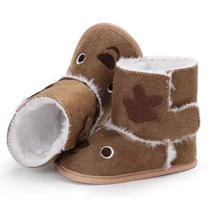Close-up of warm brown reindeer baby boots with soft white fleece lining.