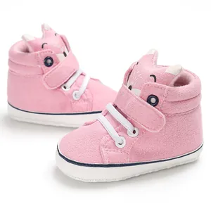 Dettaglio scarpe da camminata rosa per neonati con simpatico design a volpe e suola morbida.