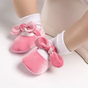 Detailed macro view of pink velvet baby shoes featuring a bow and soft anti-slip sole
