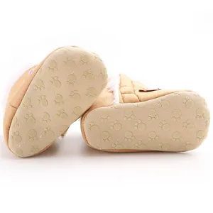 Detailed view of non-slip soft sole with paw pattern on brown infant winter snow boots