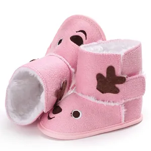 Close-up view of pink baby winter boots featuring a cute reindeer face and fuzzy lining.
