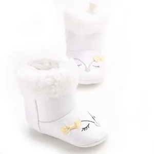 Detail view of white baby snow boots with fluffy faux fur trim and cute fox embroidery
