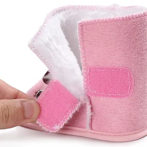 Close-up of pink baby winter boots featuring soft white faux fur lining and velcro strap.