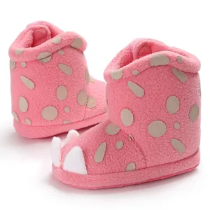 Close-up of pink baby winter boots with cute claw design and soft fleece texture