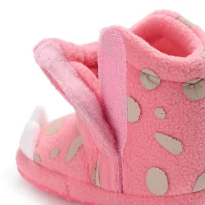 Close-up detail of soft pink fleece baby bootie featuring secure hook and loop closure