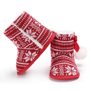 Close-up detail of red and white Christmas baby knit boots with snowflake pattern