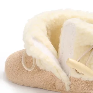 Close-up of baby winter snow boots with warm faux fur lining and wooden toggle button