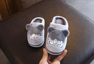 Détail de chaussons d'hiver en peluche grise pour enfants avec broderie Puppy mignonne.