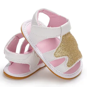 Vista detallada de sandalias para bebé niña en blanco y rosa con corona de purpurina dorada.