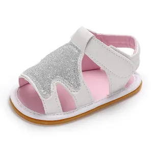 Detalle de sandalia blanca para bebé niña con forro rosa y diseño de corona brillante.