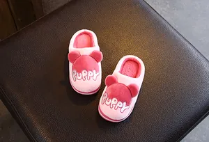Détail de chaussons en peluche rose pour enfants avec broderie Puppy mignonne