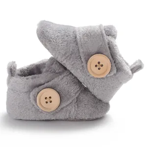 Detailed view of soft grey plush baby walker shoes featuring a large wooden button