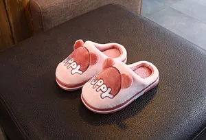 Vue détaillée de pantoufles en peluche rose pour enfants avec broderie de chiot