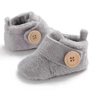 Detailed view of soft grey plush baby pre-walker shoes with wooden button decoration