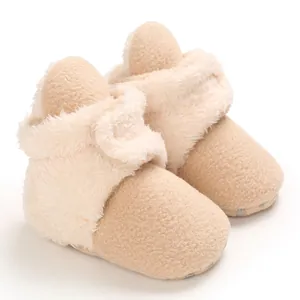 Detalle macro de botas de nieve beige de felpa para bebé con forro suave de invierno.