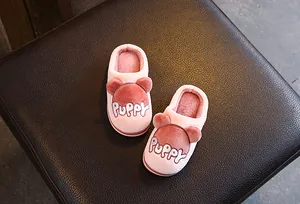 Gros plan de chaussons en peluche roses pour enfants avec oreilles d'ours brodées