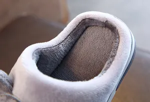Gros plan sur la doublure en peluche grise des chaussons d'hiver pour enfants