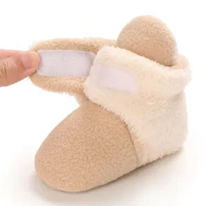 Detalle del cierre de velcro ajustable en una bota de nieve de forro polar para bebé